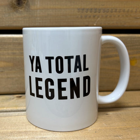 White ceramic mug with black text saying Ya Total Legend