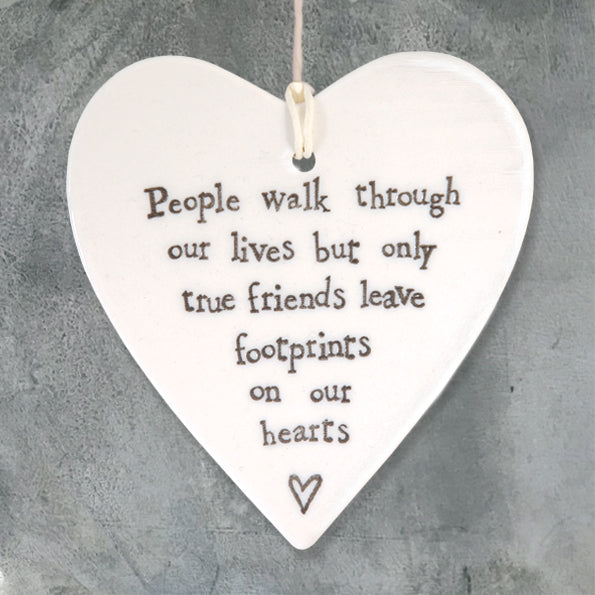 White Hanging Porcelain Heart from East of India which reads:  'People walk through our lives but only true friends leave footprints on our hearts'