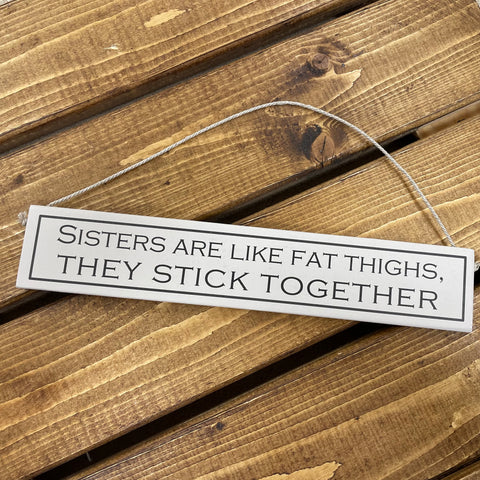 This hilarious wooden sign has to be the perfect gift for those sisters who have stuck by you through thick and thin - and sure to give them a giggle.     Rustic hanging wooden sign - hand painted with the printed slogan:  'Sisters are like fat thighs, they stick together'  Handmade in the UK