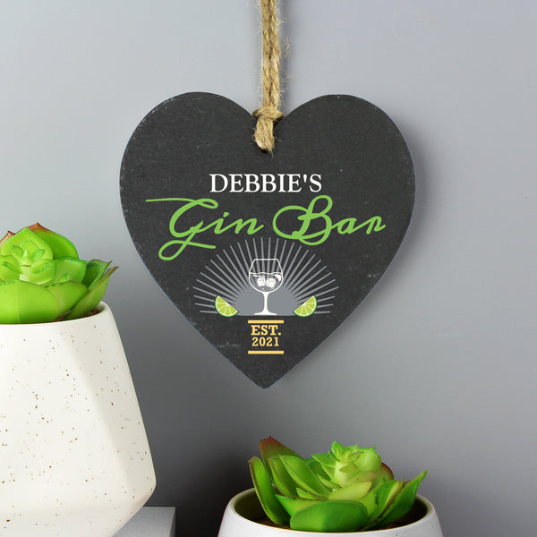 Slate hanging heart sign with natural, rustic string which can be personalised with a name of  your choice. A perfect gift for any Gin lover!  Personalise with a name up to 12 characters long (will appear in fixed upper case) and a year up to 4 characters. Gin Bar & EST is fixed text.