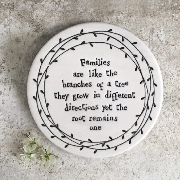 White porcelain round coaster with black text - Families are like the branches of a tree ...