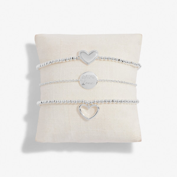 Set of three silver stacking bracelets on suede pillow