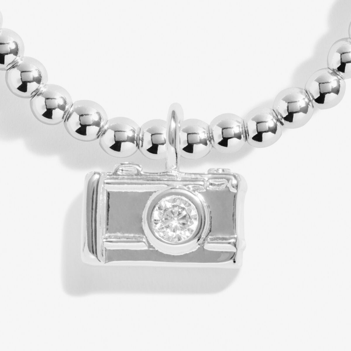 Joma jewellery stretch beaded bracelet in sterling silver with hanging camera charm presented o a foil stamped sentiment card.