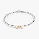 Joma Jewellery beaded bracelet with three interlinked hearts in silver, gold and rose gold presented on a blush pink sentiment card.