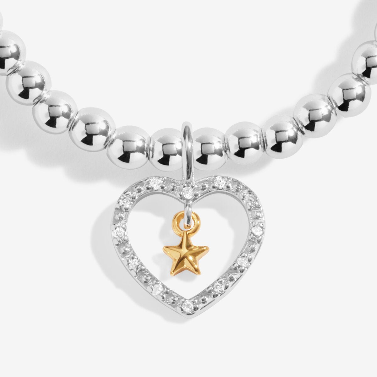 Joma Jewellery bracelet with open sparkling heart charm with hanging gold star on a white foil stamped sentiment card.