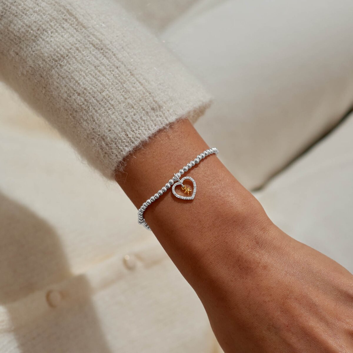 Joma Jewellery bracelet with open sparkling heart charm with hanging gold star on a white foil stamped sentiment card.