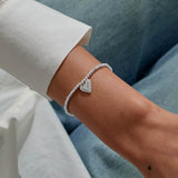 Joma jewellery beaded stretch bracelet with hanging heart charm with sparkle detail presented on a foil stamped sentiment card.