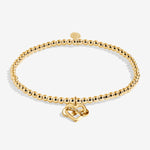 Gold plated Joma Jewellery bracelet with open heart hanging charm with infinity symbol and sparkle detail. Presented on a foil stamped sentiment card.