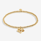Gold plated Joma Jewellery bracelet with open heart hanging charm with infinity symbol and sparkle detail. Presented on a foil stamped sentiment card.