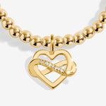 Gold plated Joma Jewellery bracelet with open heart hanging charm with infinity symbol and sparkle detail. Presented on a foil stamped sentiment card.