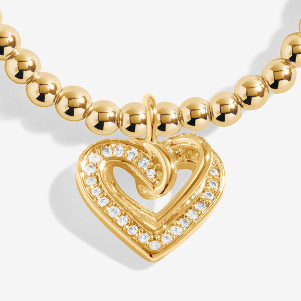 Gold plated Joma Jewellery bracelet for a friend with an open heart hanging charm with sparkle detail. Presented on a foil stamped sentiment card.