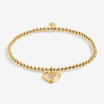 Gold plated Joma Jewellery bracelet with open hanging heart charm with sparkling lightning bolt. Presented on a foil stamped sentiment card.