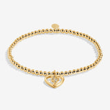 Gold plated Joma Jewellery bracelet with open hanging heart charm with sparkling lightning bolt. Presented on a foil stamped sentiment card.