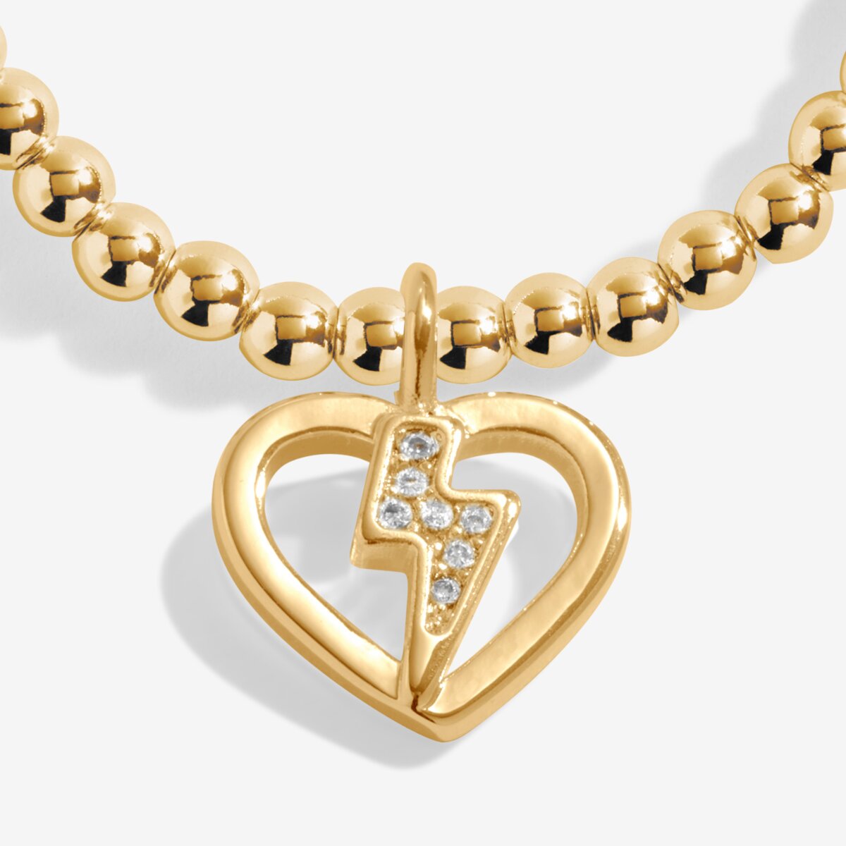 Gold plated Joma Jewellery bracelet with open hanging heart charm with sparkling lightning bolt. Presented on a foil stamped sentiment card.