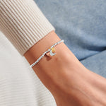 Silver plated beaded stretch Joma Jewellery bracelet with trio of charms - silver moon, gold and rose gold hearts. Presented on a sentiment card ready for gifting.