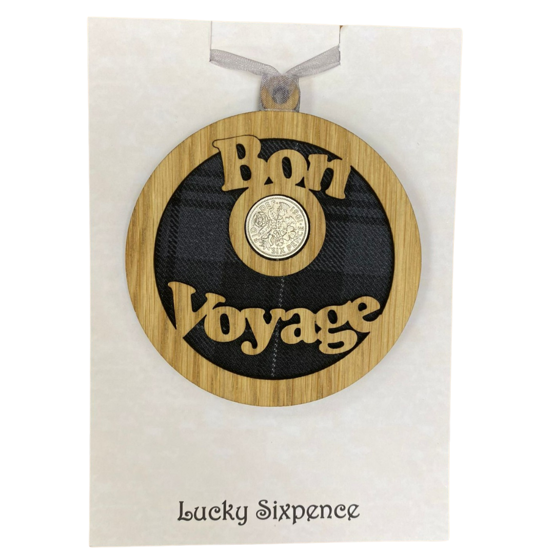 A unique keepsake gift with a Scottish twist.  The sixpence is mounted onto a round hanging oak veneered wood with tartan insert, mounted on card and packaged in clear cellophane packets.  'Bon Voyage' is laser cut into the wooden hanging.