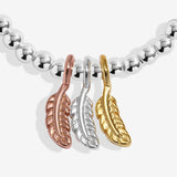 Joma jewellery stretch beaded bracelet with three hanging feather charms in silver, gold and rose gold plating presented on a foil stamped sentiment card.