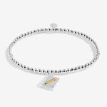 Joma jewellery girls stretch beaded bracelet with hanging book and pencil charm presented on a blush pink sentiment card.