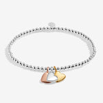 Joma jewellery stretch beaded bracelet with three solid hanging heart charms in silver, gold and rose gold plating presented on a foil stamped sentiment card.