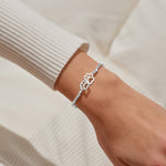 Joma jewellery silver plated stretch beaded bracelet with intertwined paw print charm presented on foil stamped sentiment card.