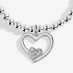 Joma jewellery stretch beaded bracelet with hanging heart charm with small sparkling heart presented on a foil stamped sentiment card.