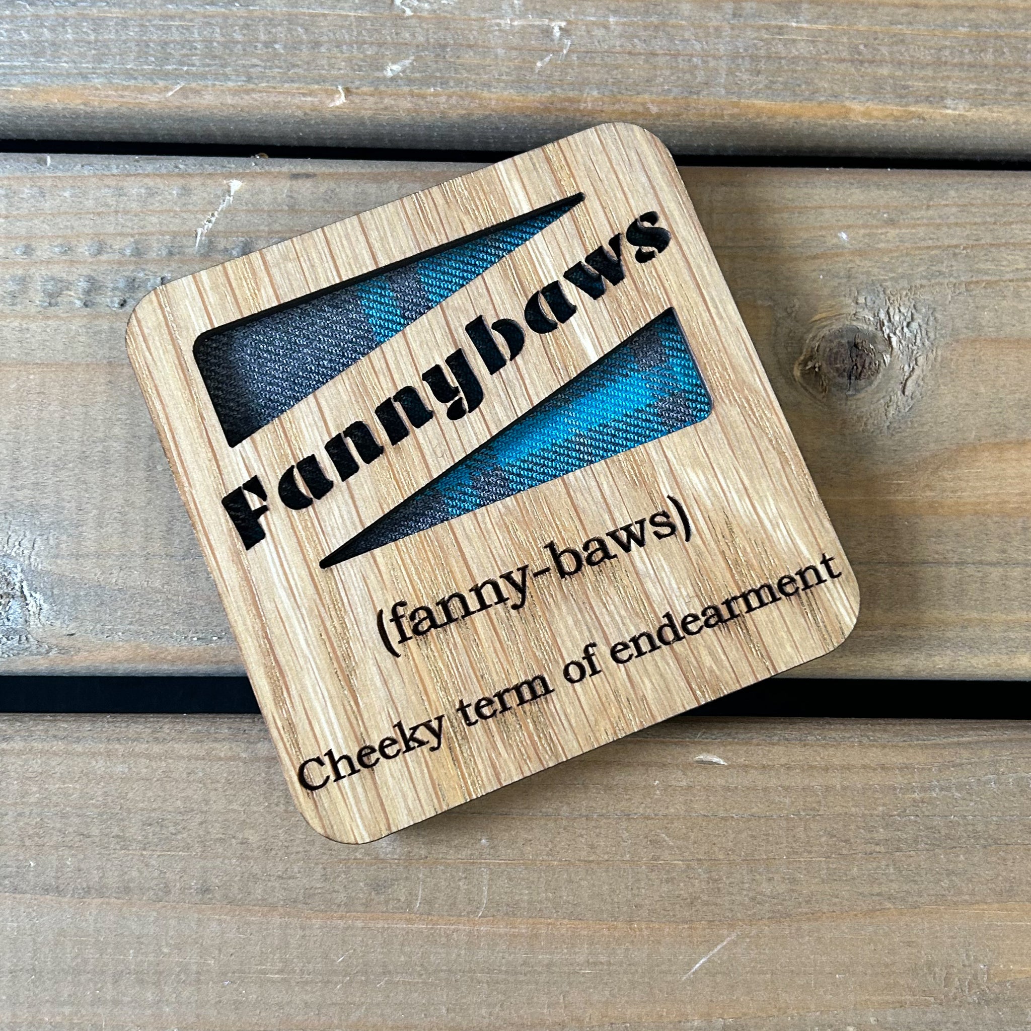 Oak veneer coaster with tartan insert with the cut out word 'Fannybaws' with an engraved definition.