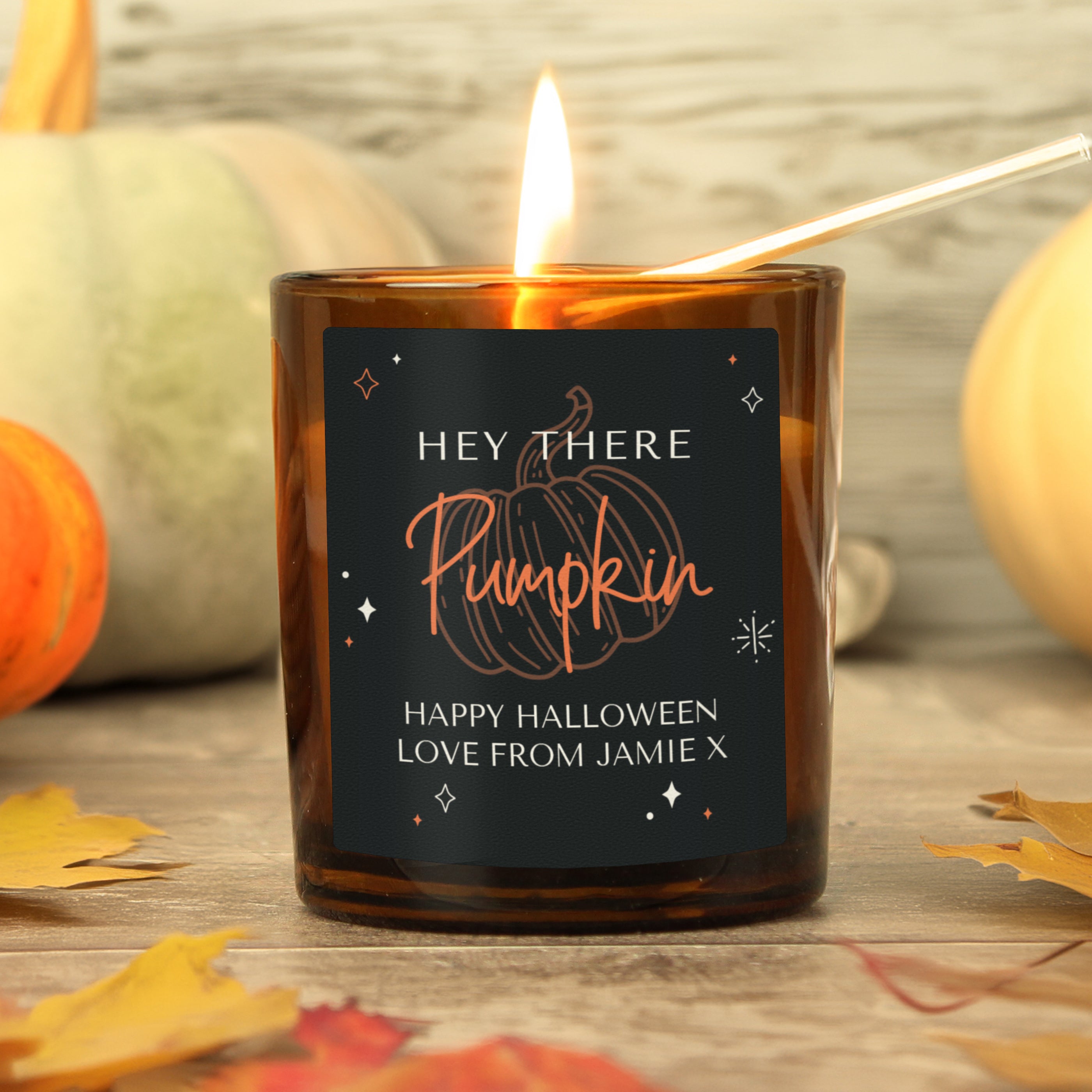 Personalised amber glass candle with pumpkin design.