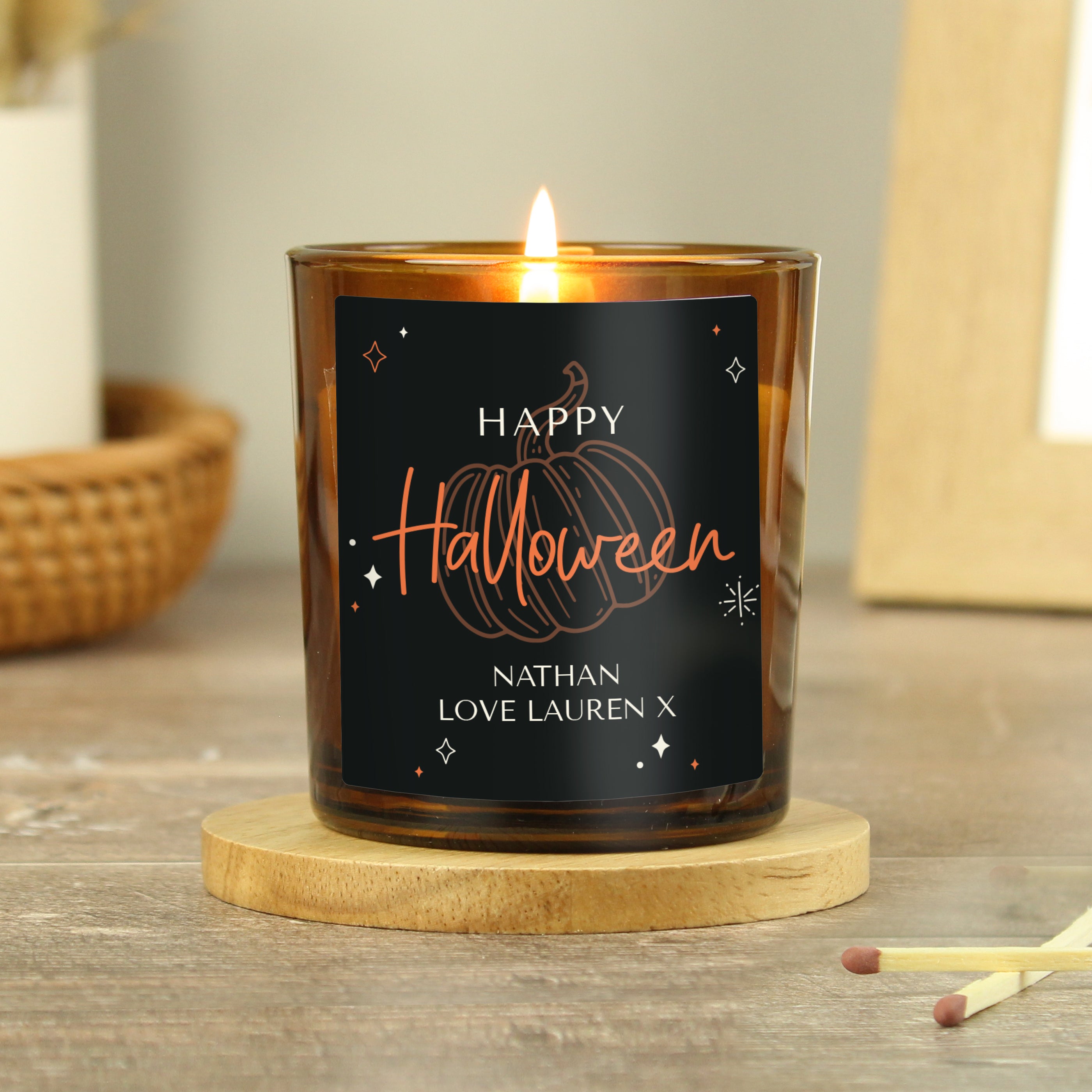 Personalised amber glass candle with pumpkin design.