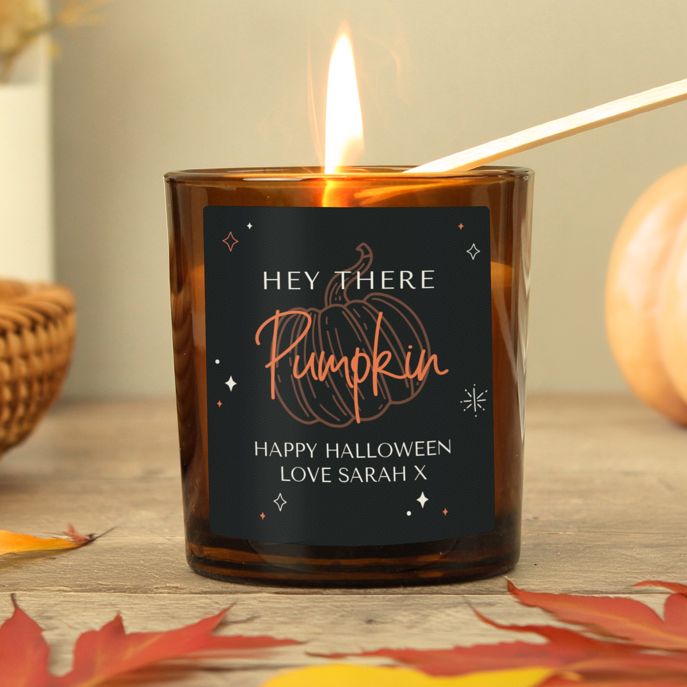 Personalised amber glass candle with pumpkin design.