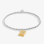 Joma girls beaded bracelet with gold plated book charm