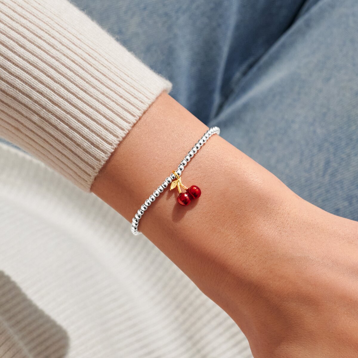 Joma jewellery stretch beaded silver plated bracelet with red cherry charm presented on a sentiment card.