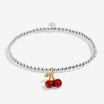 Joma jewellery stretch beaded silver plated bracelet with red cherry charm presented on a sentiment card.