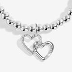 Silver beaded bracelet with a interlocking heart-shaped charms on a white background