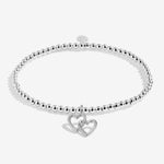 Silver bracelet with interlocking heart charms on a white background