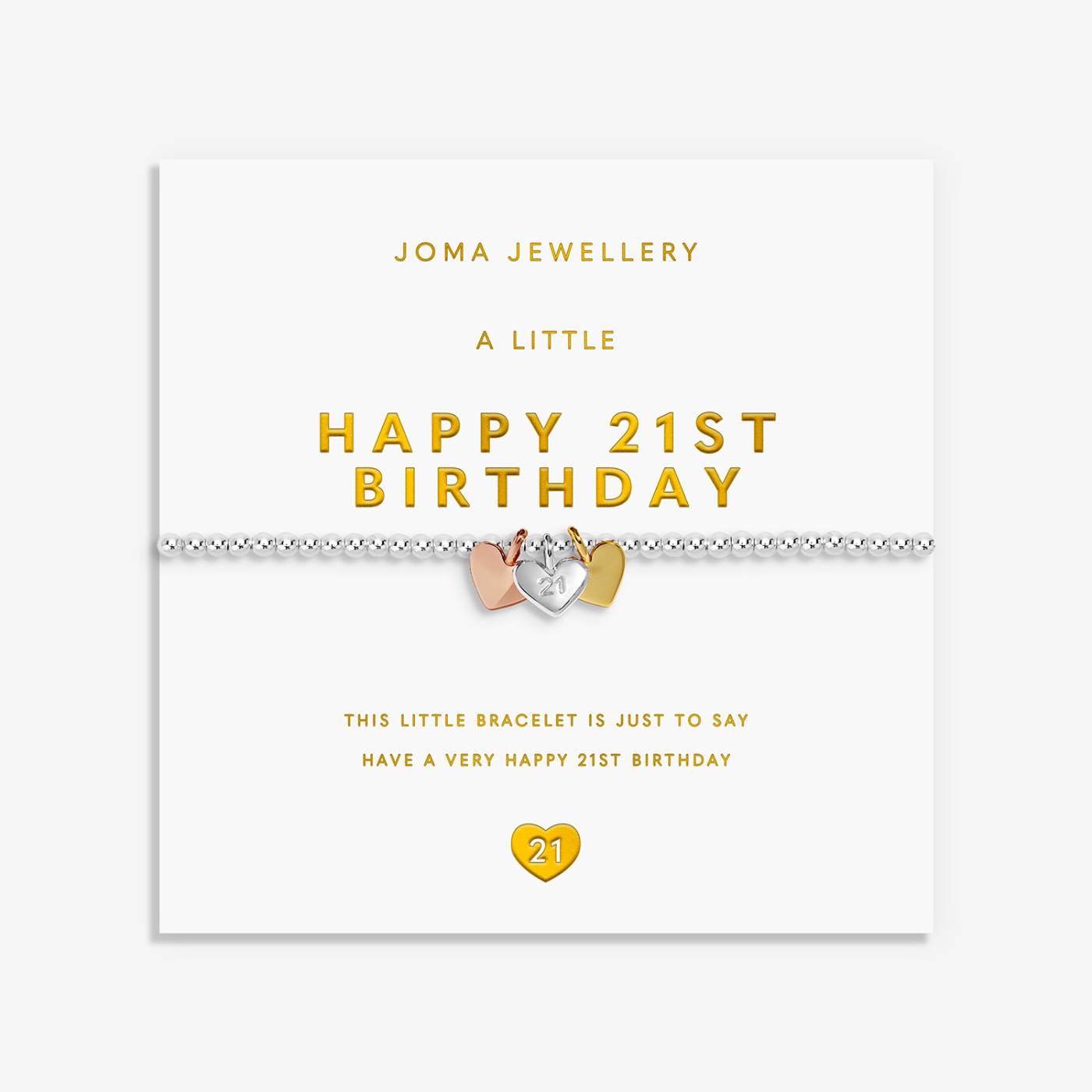 A 21st birthday bracelet by Joma Jewellery on its white retail card packaging. The bracelet features a silver chain with a central heart charm split into three colours: rose gold, yellow gold, and silver