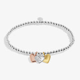 Silver bracelet with three heart-shaped charms on a white background