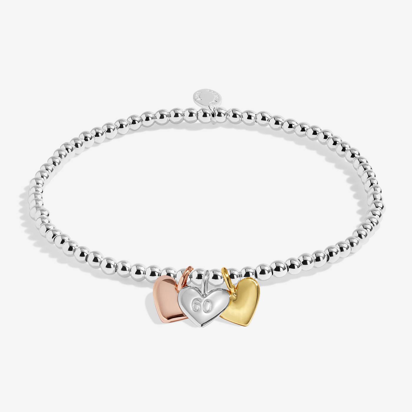Silver bracelet with three heart-shaped charms on a white background