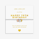 A silver 70th birthday bracelet by Joma Jewellery, featuring 3 heart charms in silver, gold and rose gold displayed on its white gift card with gold lettering.