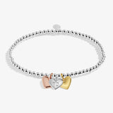 Silver bracelet with three heart-shaped charms on a white background