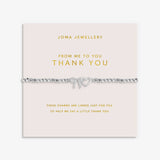A silver beaded bracelet with heart charm and bow charm, presented on a pale pink card from Joma Jewellery that reads 'FROM ME TO YOU THANK YOU'.