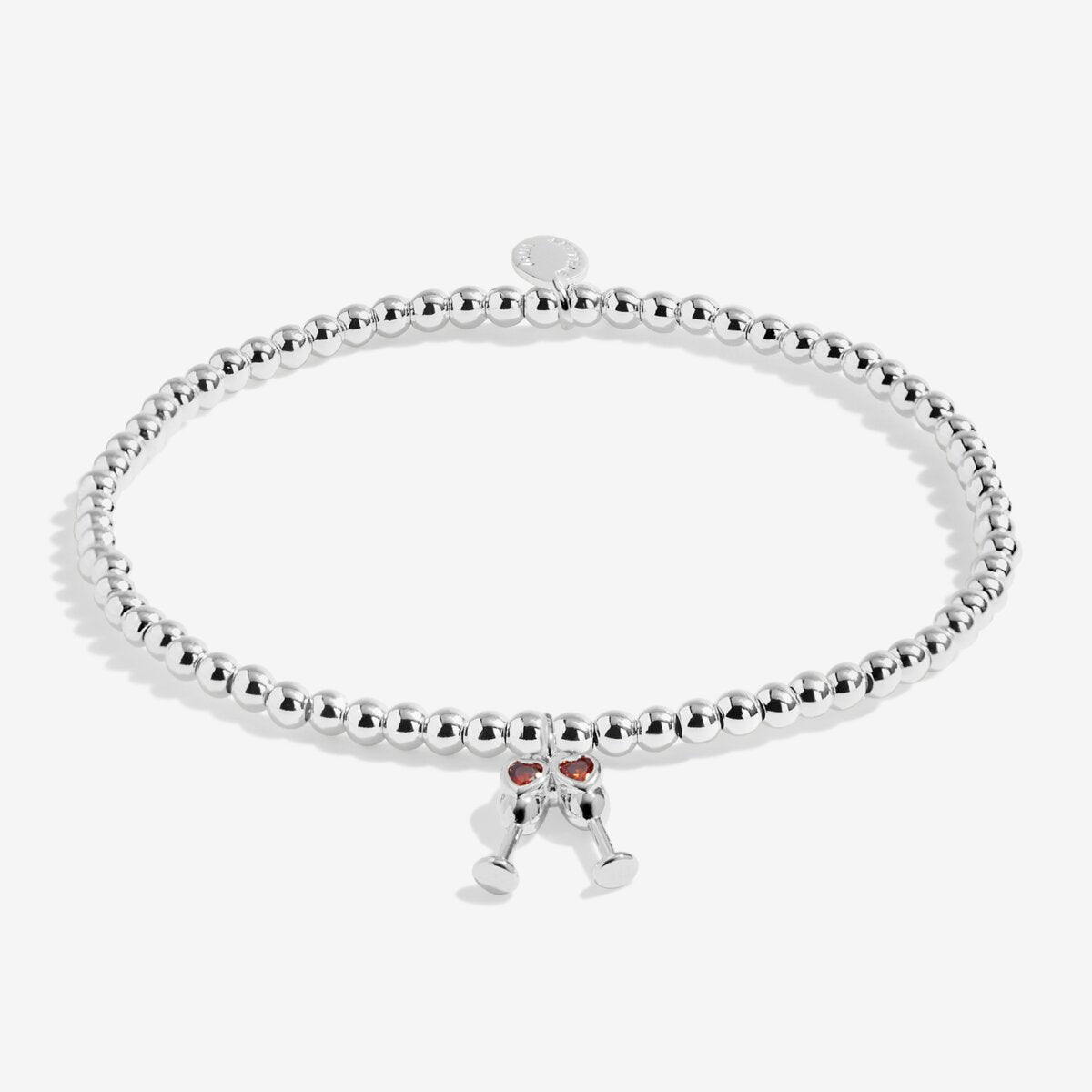 Joma Jewellery beaded stretch bracelet with hanging charm featuring 2 champagne glasses with red sparkle detail.