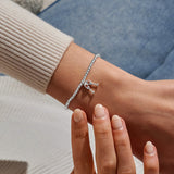 Joma Jewellery beaded stretch bracelet with hanging charm featuring 2 champagne glasses with red sparkle detail.