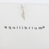 A silver wing-shaped pendant hanging from a white ribbon against a white background with the brand name 'equilibrium' printed below.
