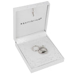 A silver angel keychain displayed inside an open white gift box with the brand name 'equilibrium' printed inside the lid.