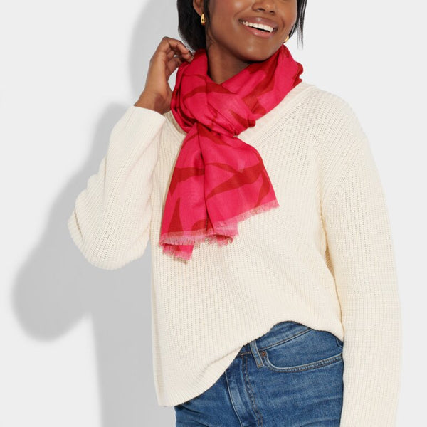 Model wearing fuchsia scarf with abstract flower print
