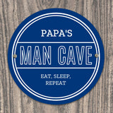 Personalised blue circular Pap's Man Cave sign with white lettering.