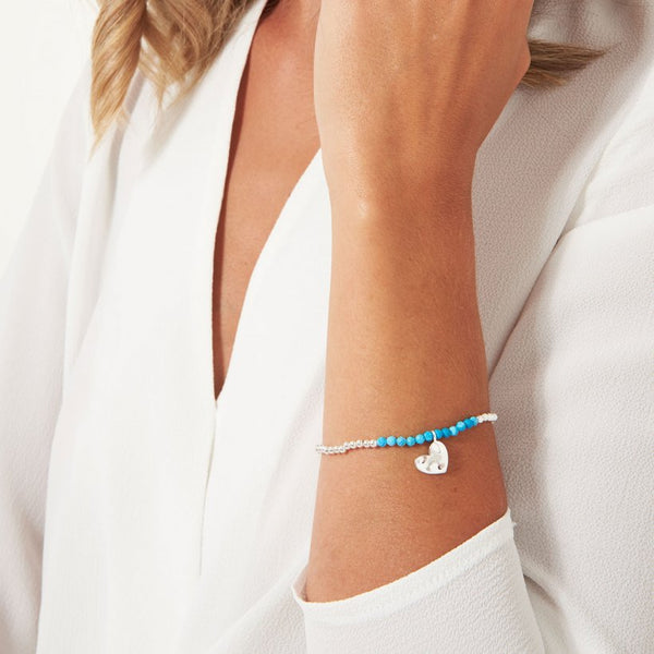 Joma Jewellery 'a little' bracelet with special turquoise gemstones and a gently hammered silver heart charm, presented on a sentiment card which reads:  'Wear this bracelet every day, because you're generous and positive in every way.'