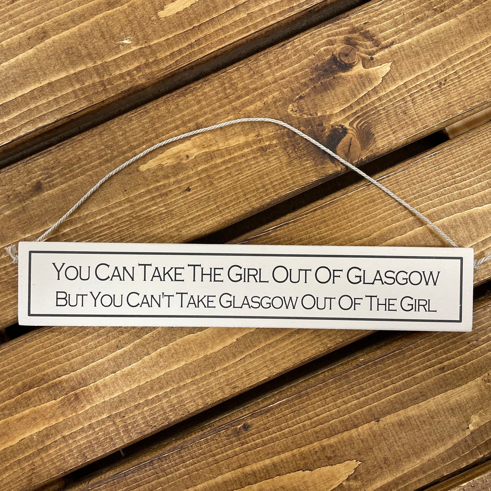 This wooden sign has to be the perfect gift for friends who love a little Scottish humour.    Rustic hanging wooden sign - hand painted with the printed slogan:  'You can take the girl out of Glasgow, but you can't take Glasgow out of the girl.'  Handmade in the UK