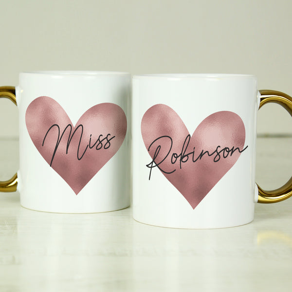 White mug with gold handle and pink heart design.  Can be personalised with a name and title eg Wife, Kathrine