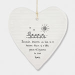 White Hanging Porcelain 'Wobbly' Round Heart from East of India which reads:  'Because someone we love is in heaven there is a little piece of heaven in our home.'  The heart features an engraved illustration in East of India's unique style.